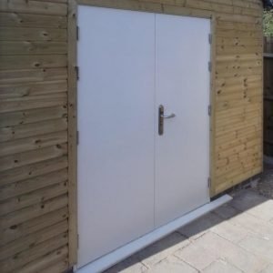 Double personal access door installed in wooden clad building
